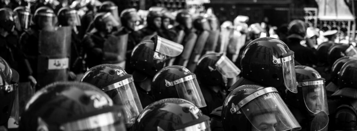 photographie en noir et blanc de policiers anti-émeute pendant une manifestation